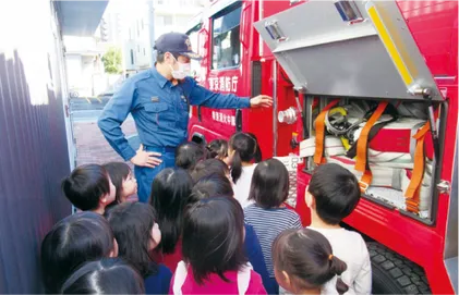 消防士さんから消防車の説明を受ける子どもたち
